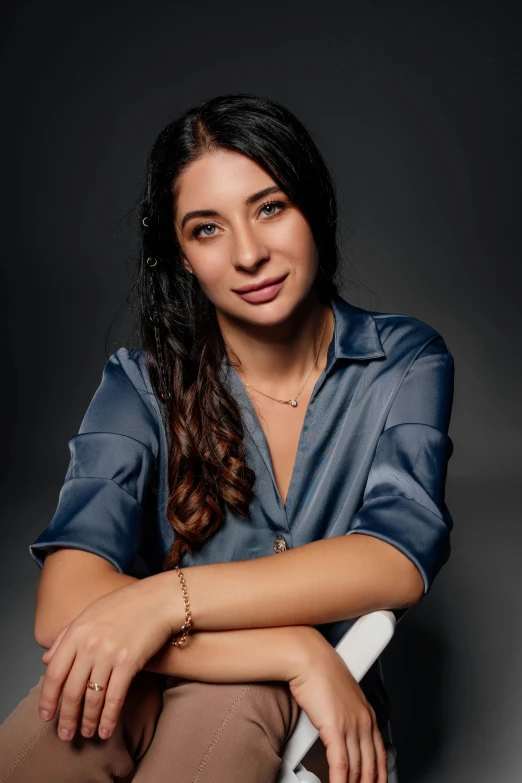 a woman in a blue shirt posing for a po