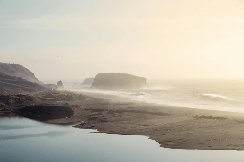 a foggy beach on a cloudy day with water flowing from it