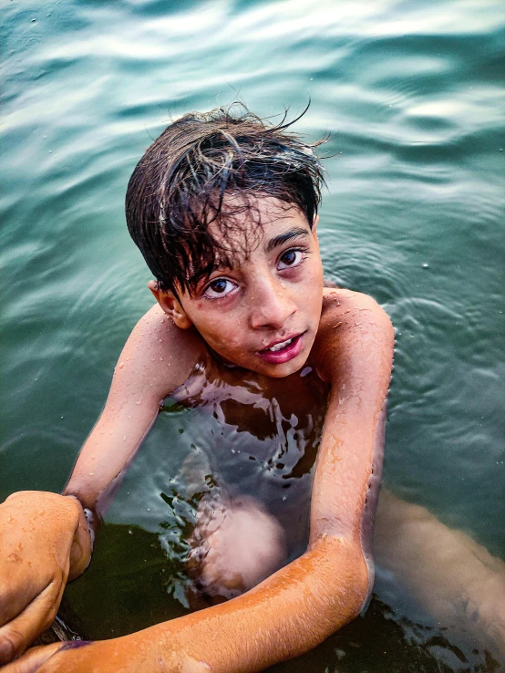 a boy with wet hair is in the water