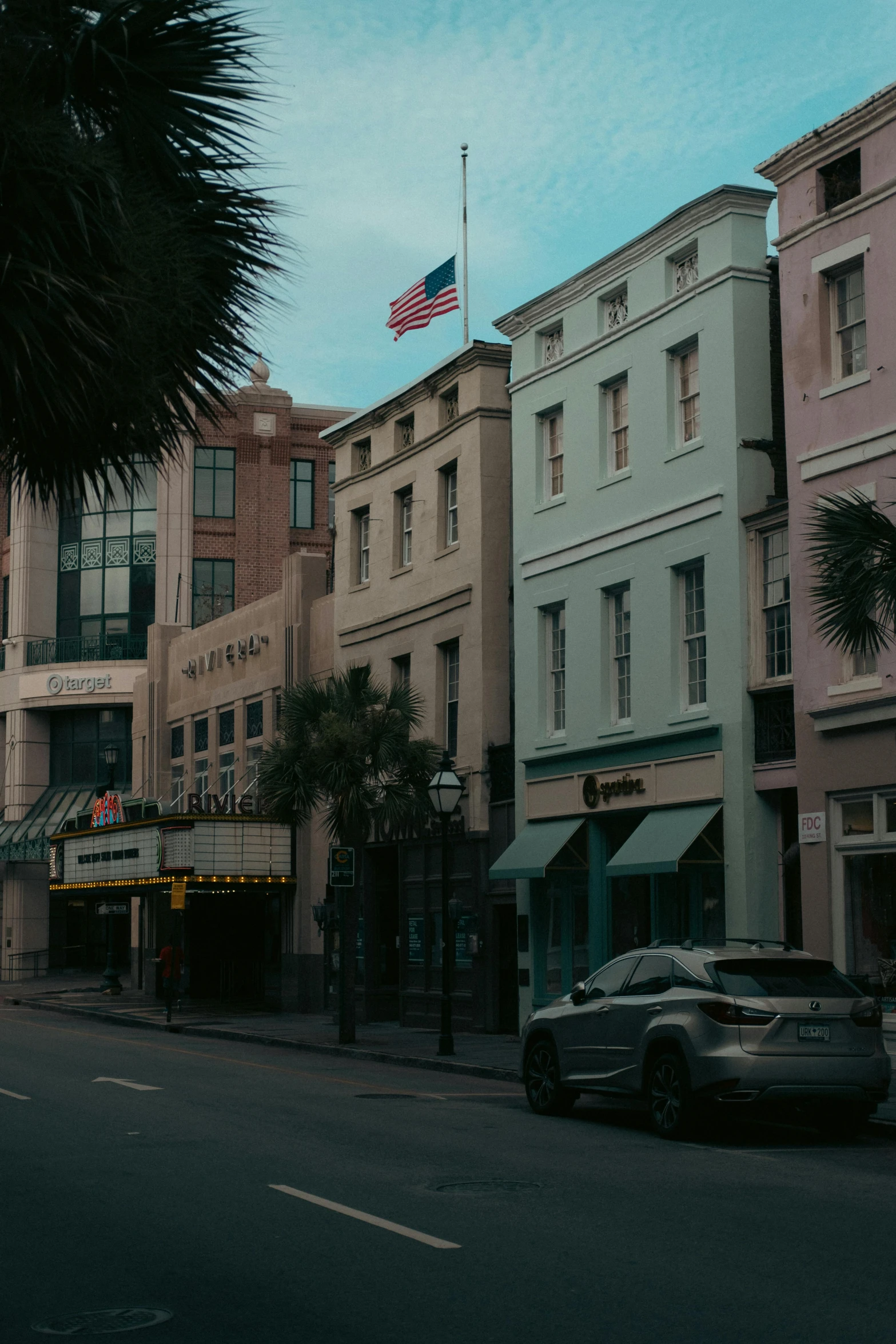 a row of building sit next to each other in front of an american flag