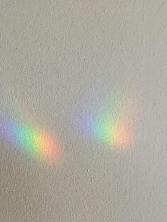 a rainbow ray shining through a dirty white wall
