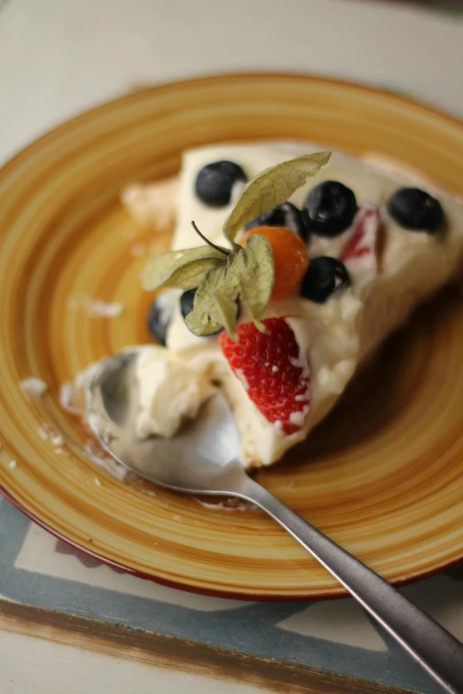 a piece of cake that has blueberries, strawberries and strawberry