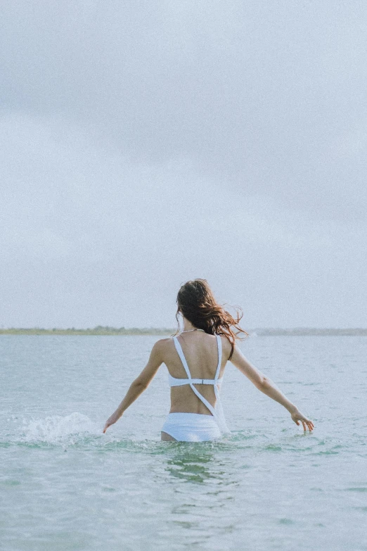 a woman in the water holding her hands out