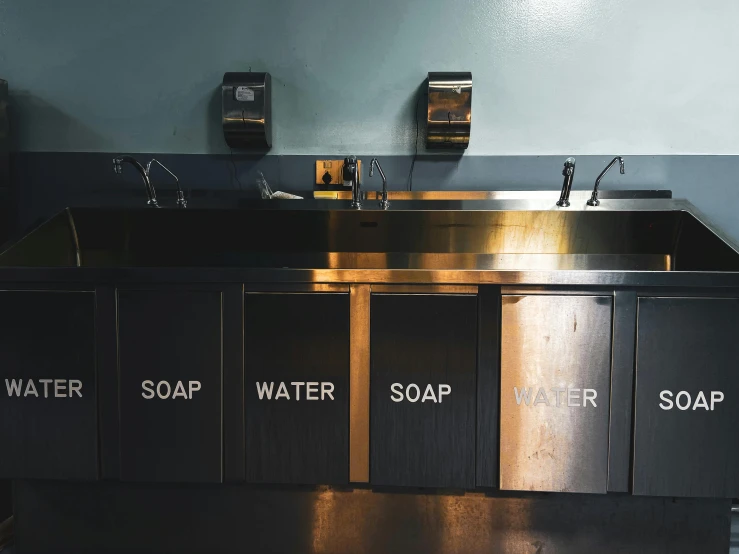 a bathroom sink that has several soaps in it