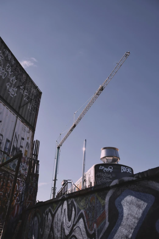 a graffiti covered building with some cranes above it