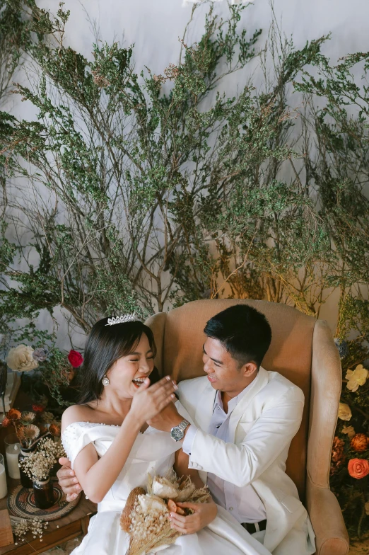 the bride and groom sit on a chair