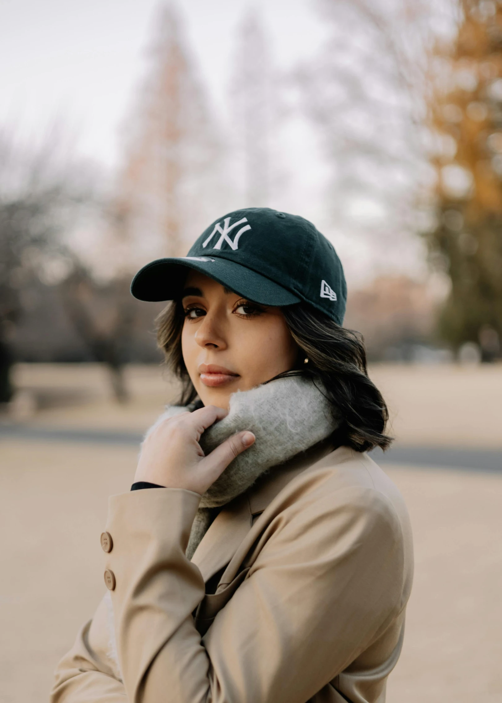 a young woman wearing a new york yankees cap while looking at the camera