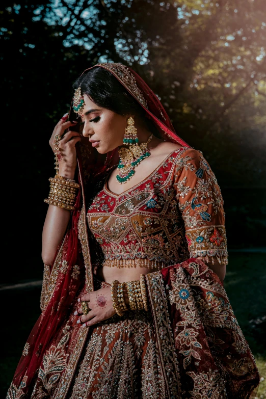 a beautiful woman wearing a bridal outfit in the middle of a forest