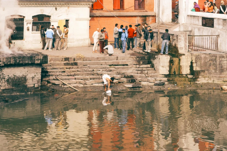 a group of people stand on some steps by the water