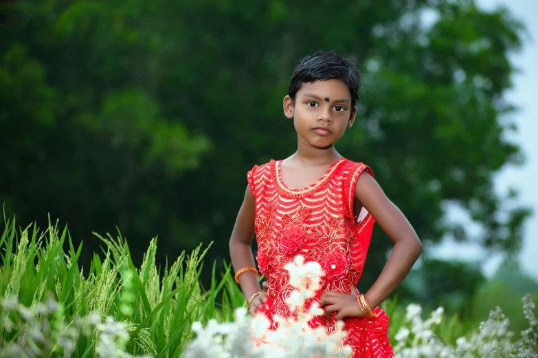 an indian girl is posing for a pograph in the grass