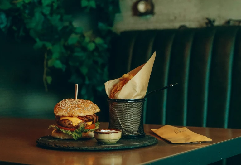 a hamburger and a basket with some dipping sauces