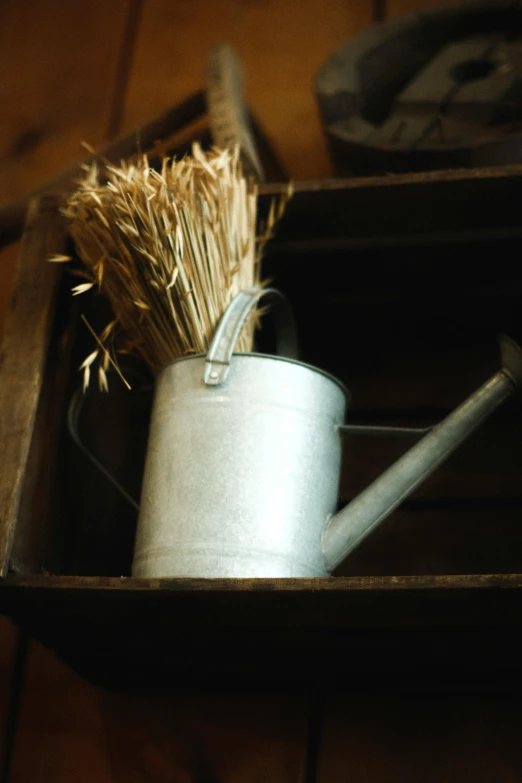 a white pot and two wooden spoons and a metal brush