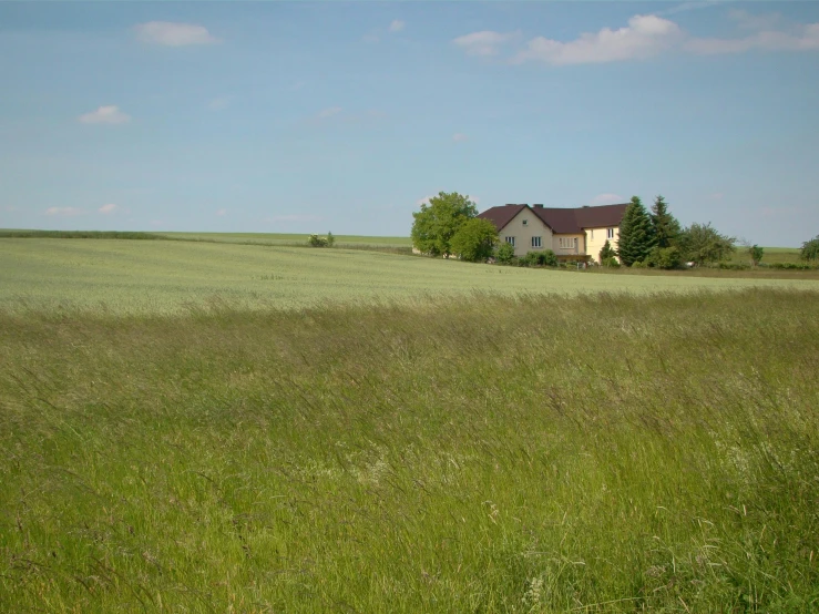 an old house in the middle of a green field