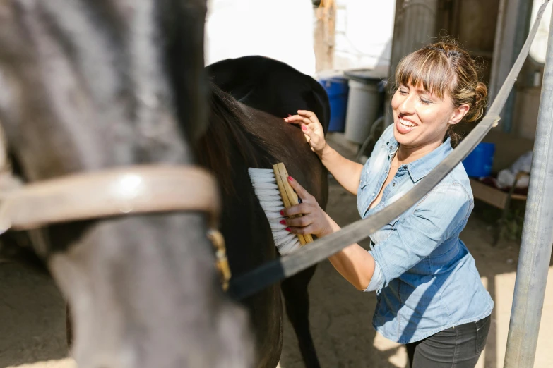 a woman is helping her horse with its reins