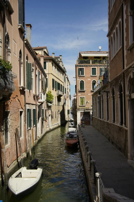 boats moored on a river side with many buildings