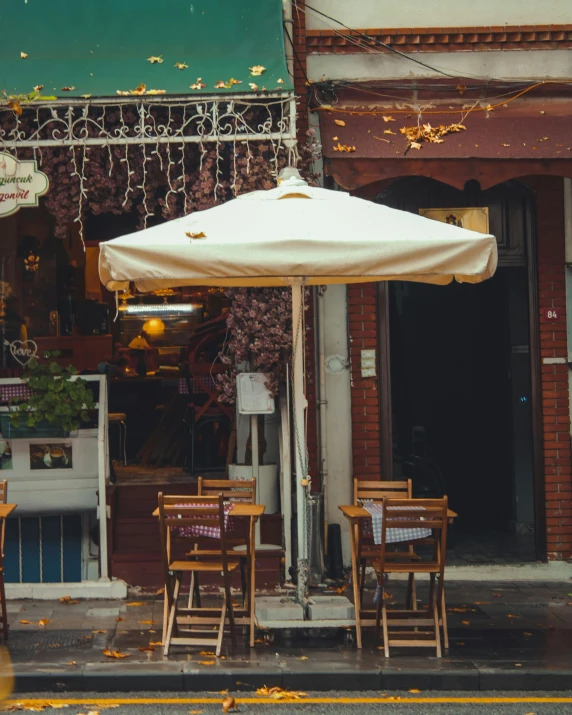 an umbrella outside of a restaurant in the middle of the city