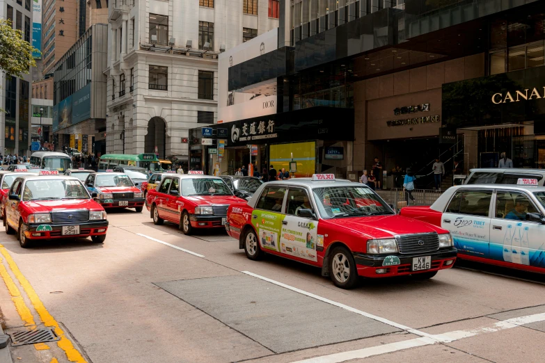 several red and white cars are driving on the street