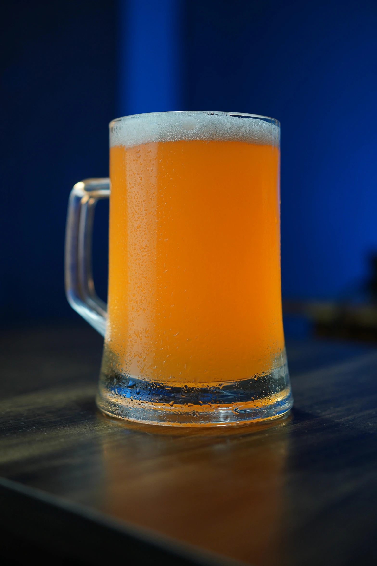 a mug of beer sitting on a wooden table