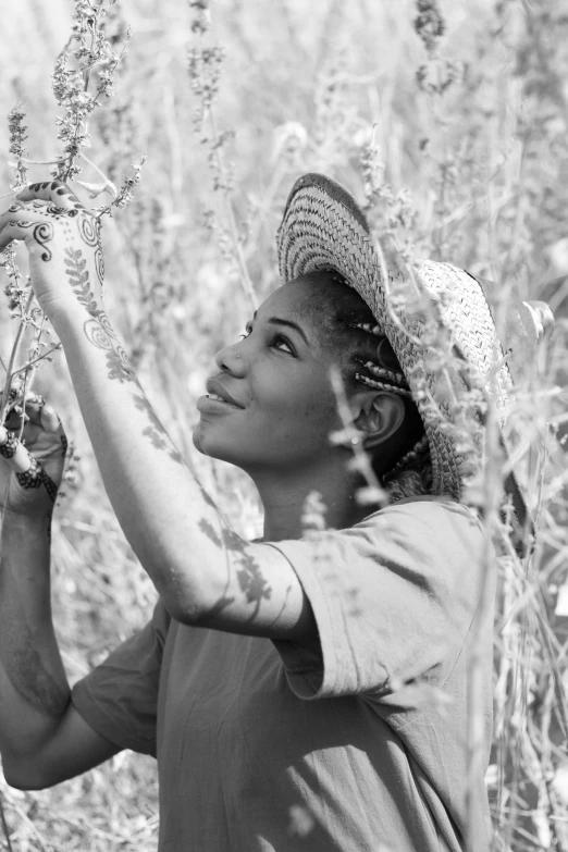 a woman wearing a hat is in the weeds
