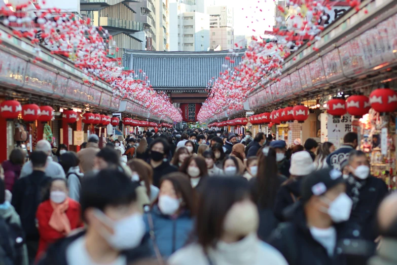 a crowded street filled with people wearing masks