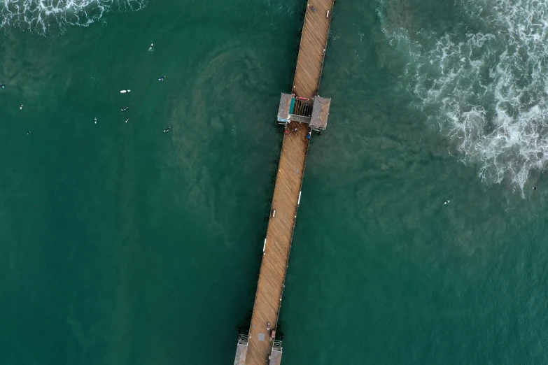 a large pier in the middle of a green ocean