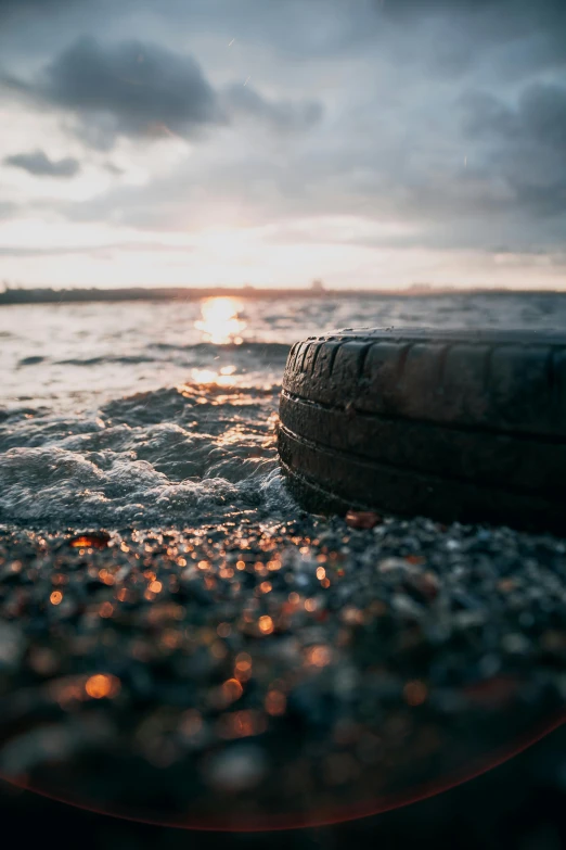 closeup of tire, seen in foreground of the ocean and sun