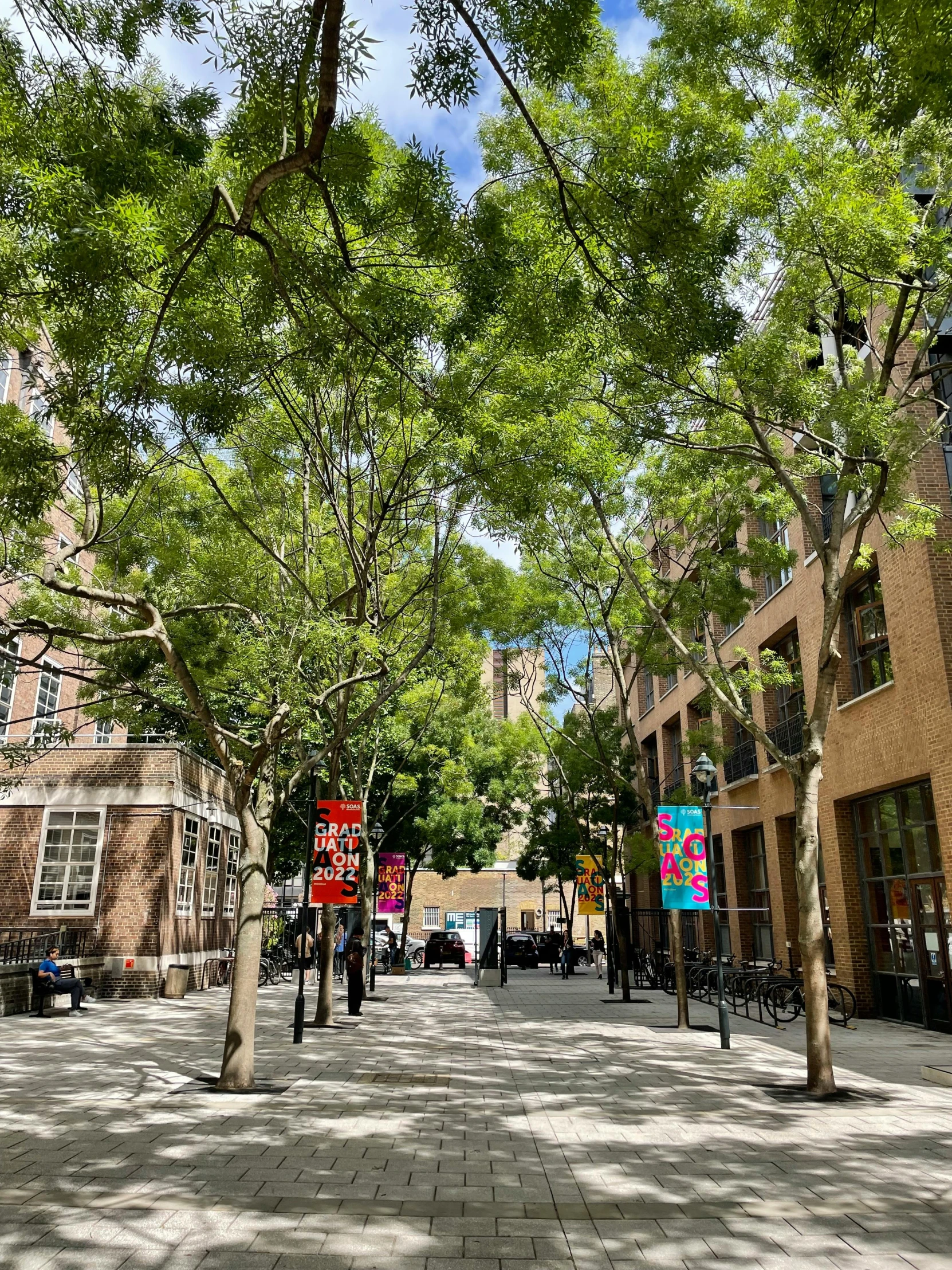 people walking on a paved street near buildings