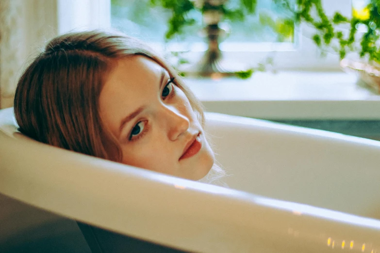 a woman laying in a tub of water
