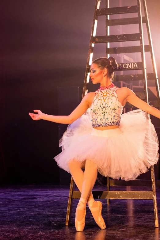 a woman is sitting on a chair in a tutu