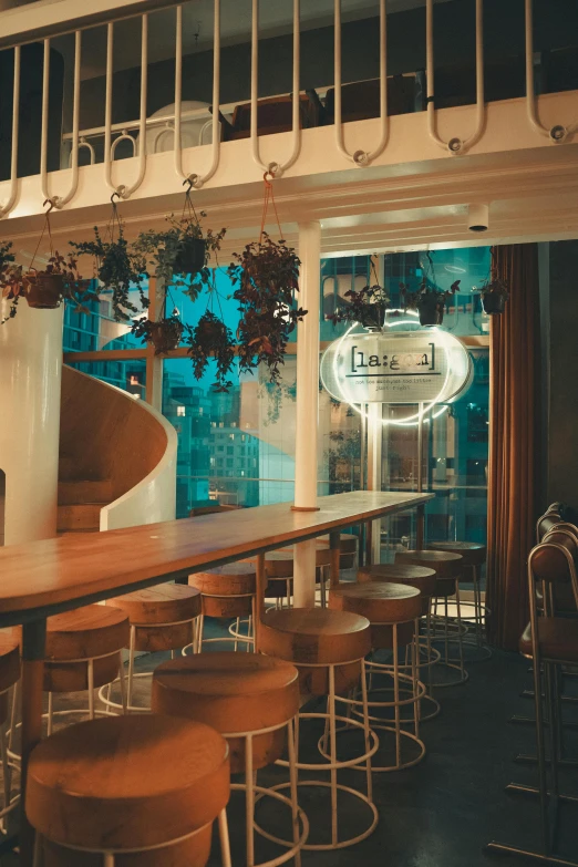 an empty bar in front of a window with plants hanging from it