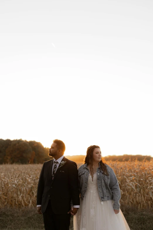 a woman and man are walking in a field