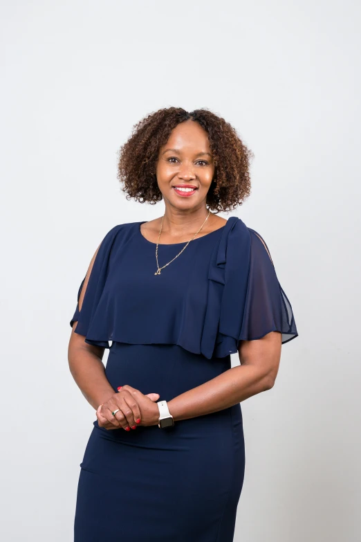 a smiling woman poses for the camera in a dress