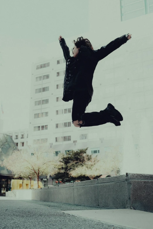 a person jumping in the air in front of buildings