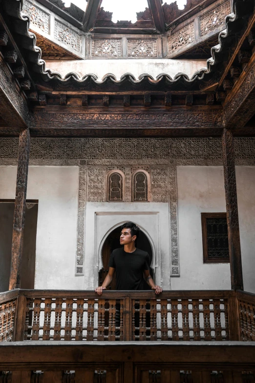 a man stands at a balcony overlooking a wooden door