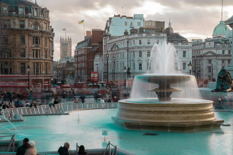 a fountain near some buildings and flags