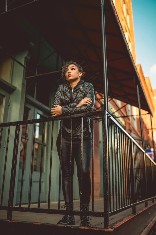 the young man stands next to the railing by the building