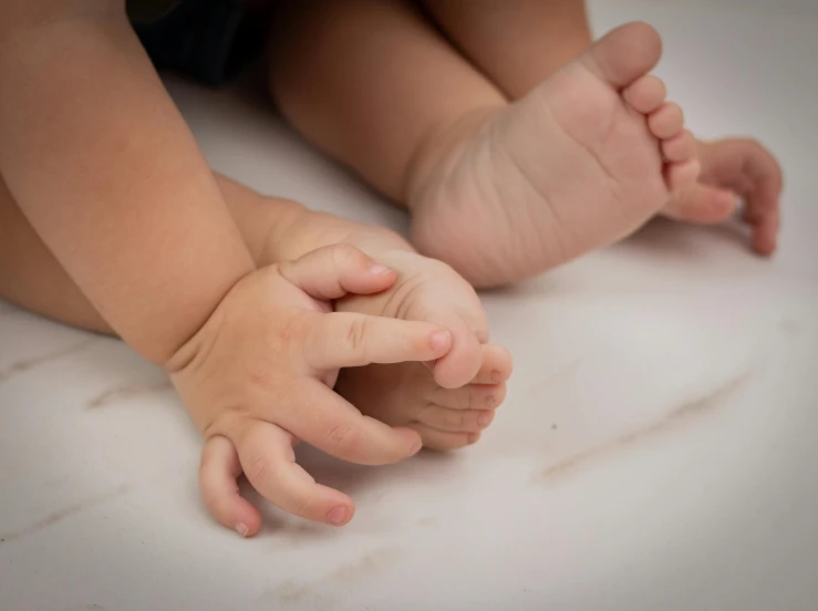 a close up of a baby holding its hands