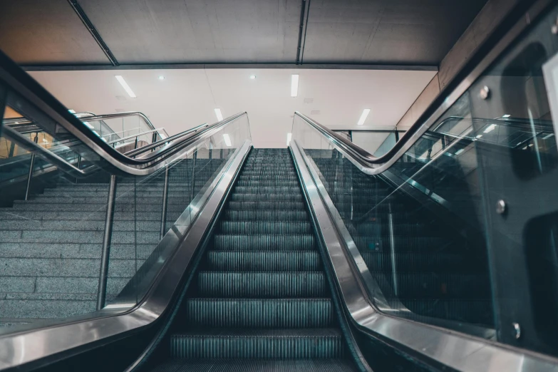 an escalator is running down a dark tiled floor