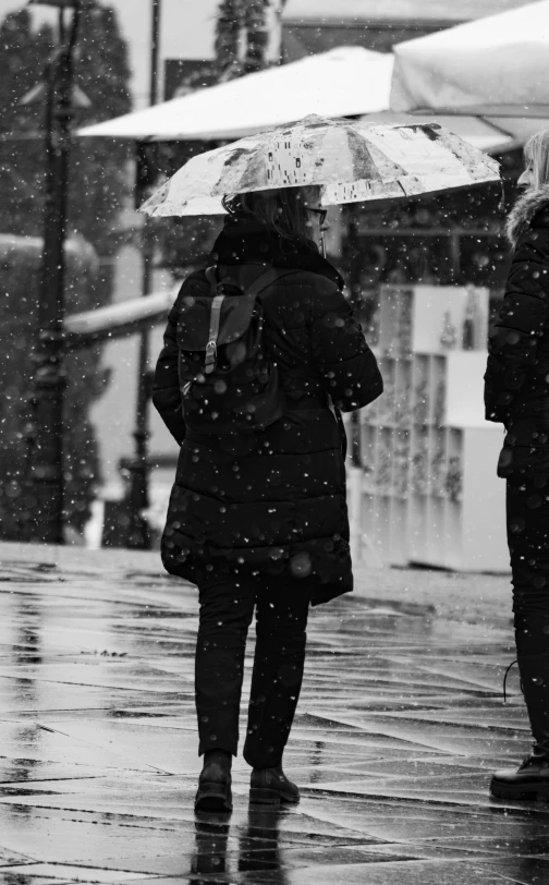 two people are walking in the rain with umbrellas