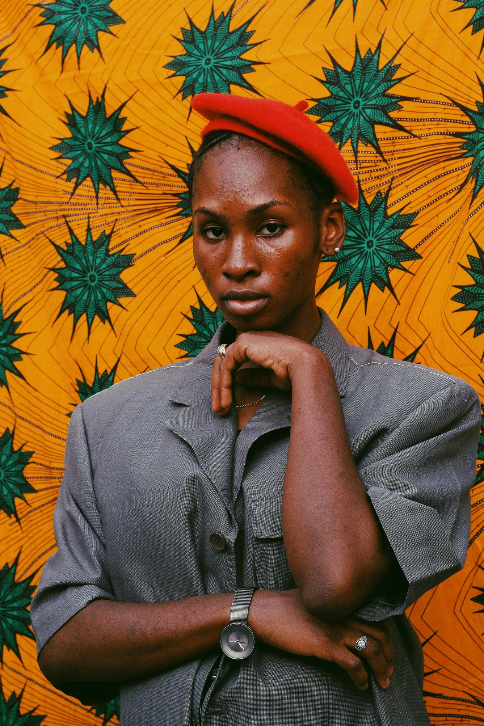 an african american woman standing in front of green and yellow wallpaper