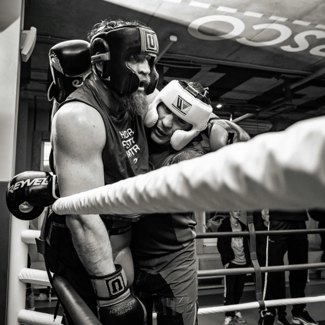 a man standing next to a punching machine with two other people in the background