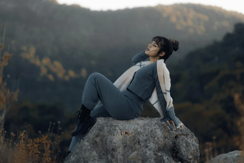 woman laying on a rock by the forest