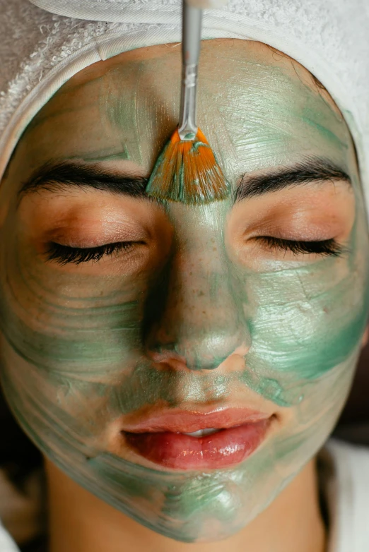 a woman's face is being bathed with a facial mask