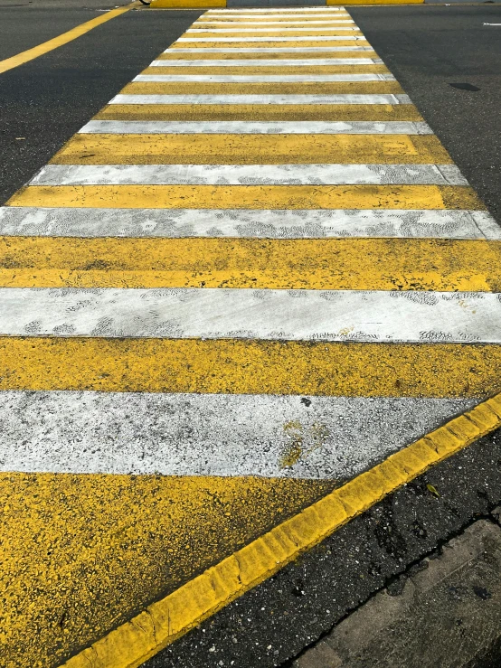 an image of a cross walk painted yellow and white