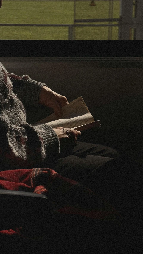 a person sitting on a couch holding an open book