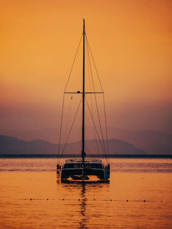 a small boat on the ocean at sunset