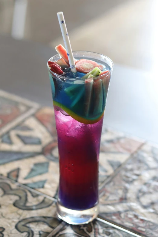 a colorful beverage with strawberries and candy in it