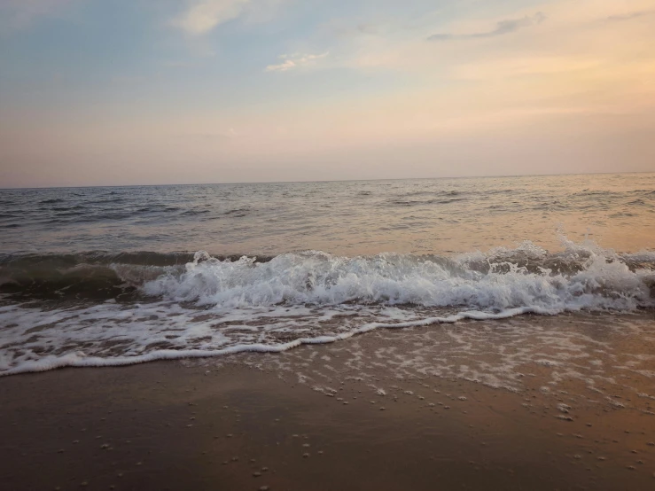 the water washes on top of the sand at the beach