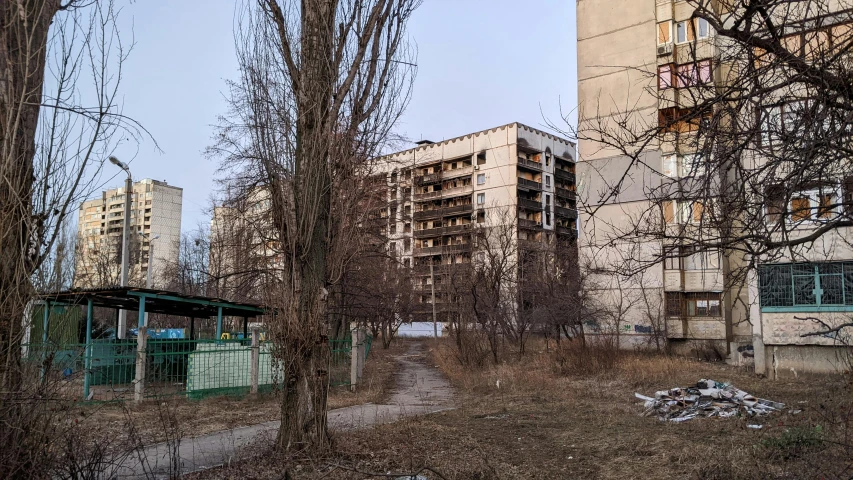 a dirty field that is near the street and buildings