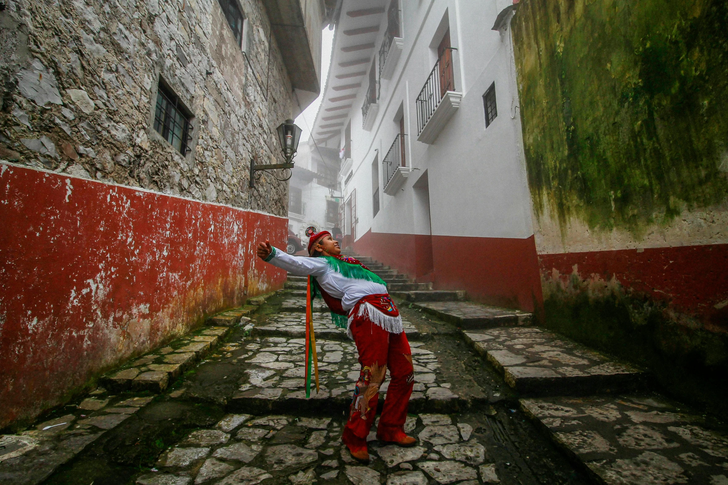 a woman in red and green is holding a pole